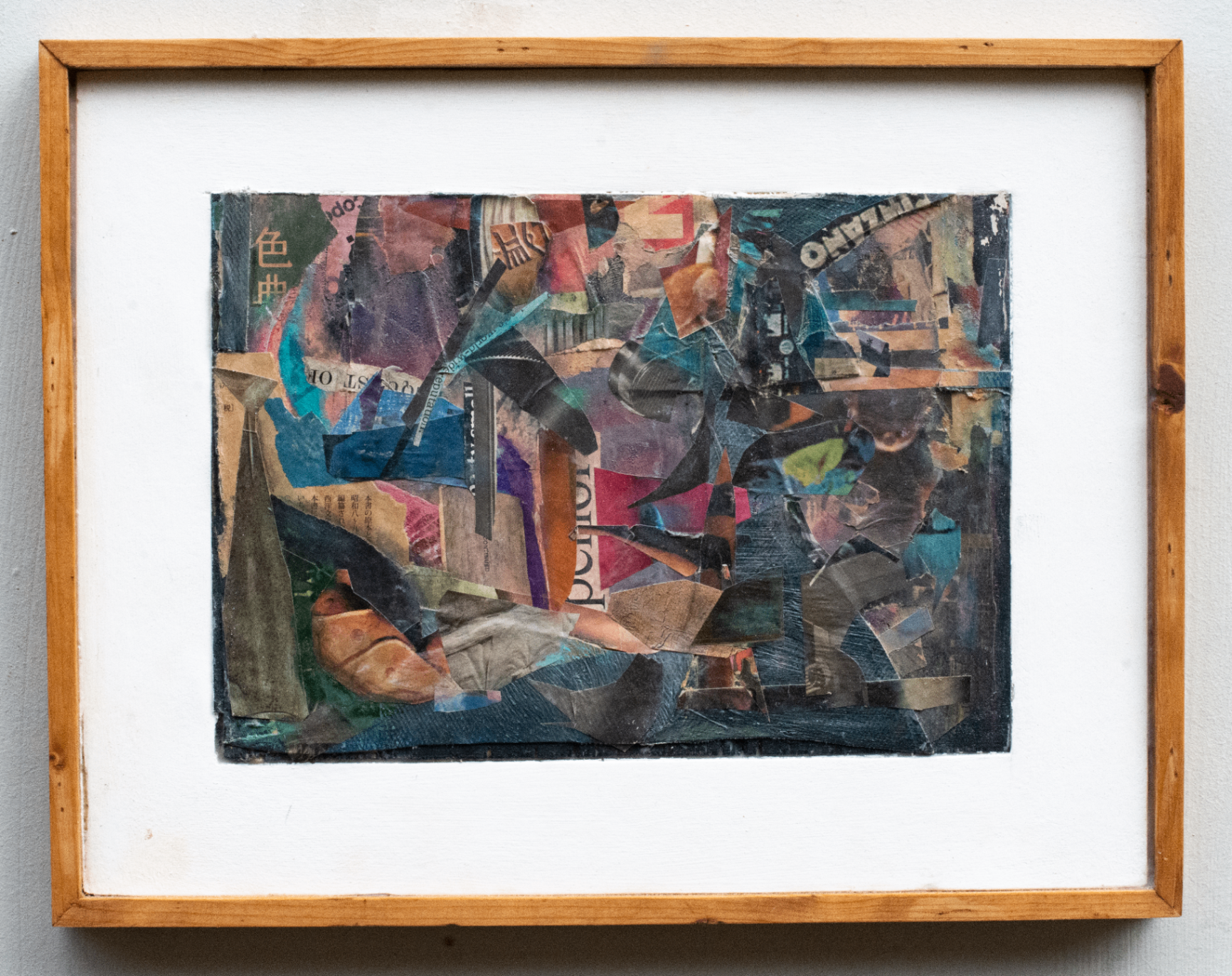 Innrammet mørk collage-komposisjon med papirfragmenter og blågrønne detaljer